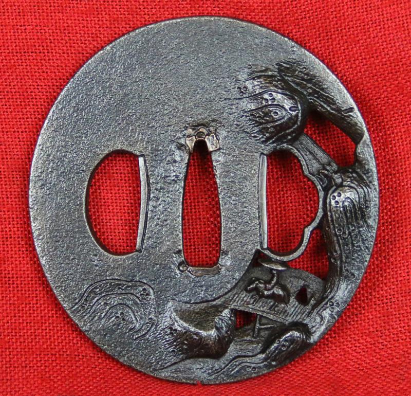 A Fine & Beautiful Edo Period Iron Tsuba in Nikubori Jisukashi Of Waterfalls Rocks and River with A wooden Bridge Being Traversed by a Figure On Horseback Carrying a Parasol